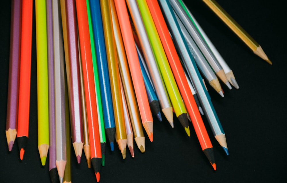 multi colored coloring pencils on black textile