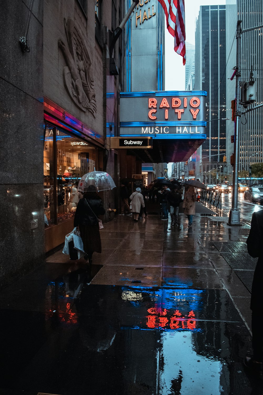 people walking on sidewalk during night time