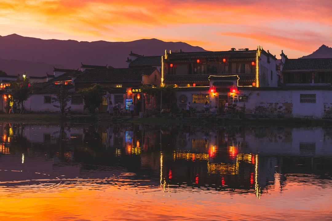 white concrete building near body of water during sunset