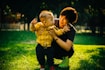 boy in yellow and black plaid button up shirt carrying girl in yellow and black plaid