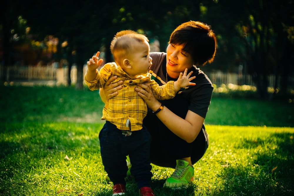 boy in yellow and black plaid button up shirt carrying girl in yellow and black plaid