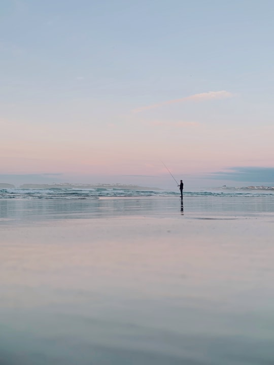 person fishing on sea during daytime in Peniche Portugal