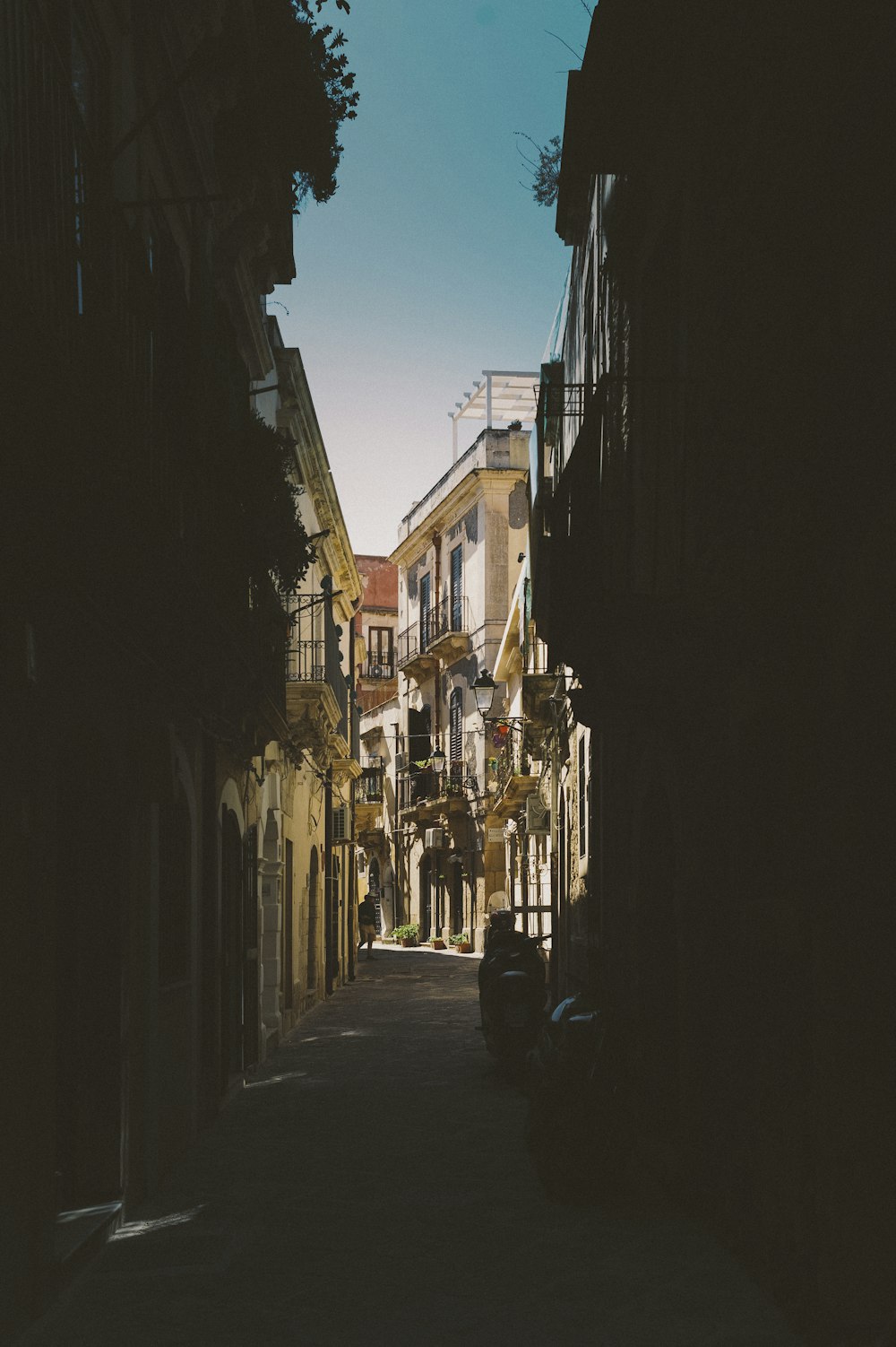 persone che camminano per strada tra gli edifici durante il giorno