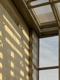 Sunlight filtering through modern architectural details of a Pune building.