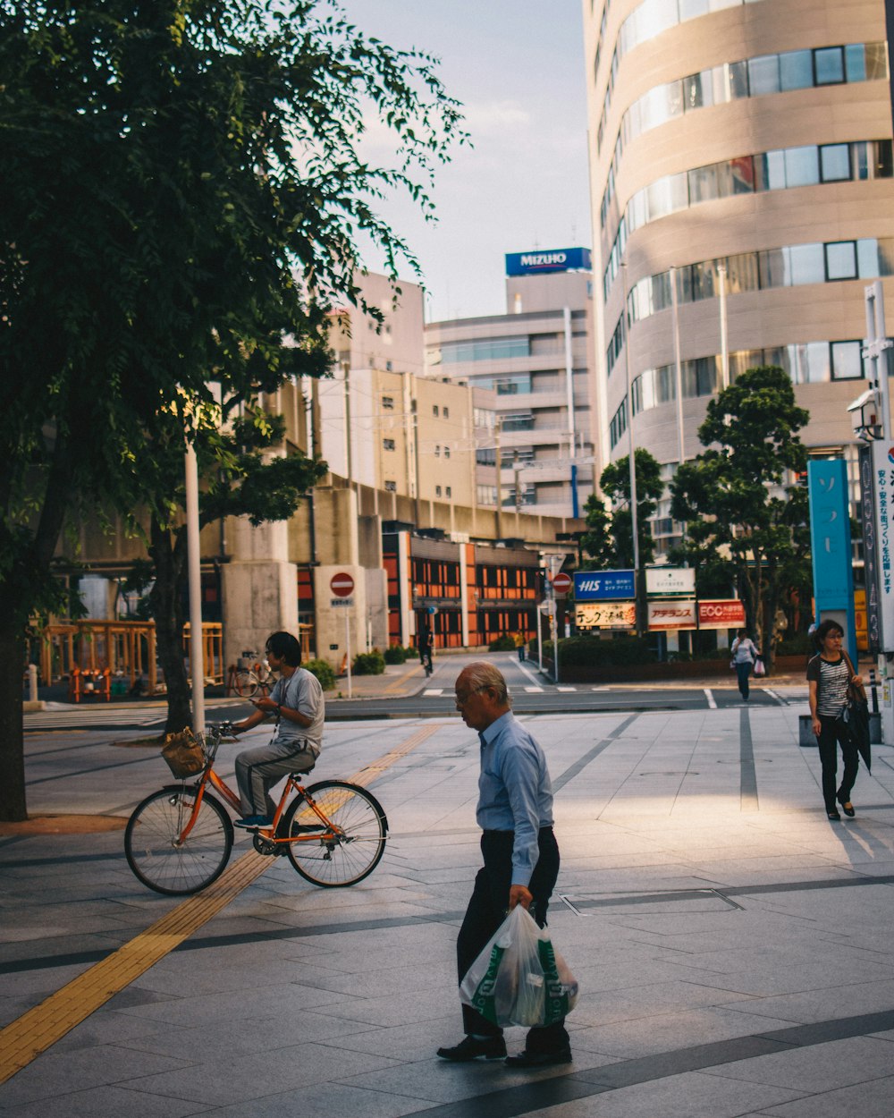 man in gray sweater and black pants walking on sidewalk during daytime