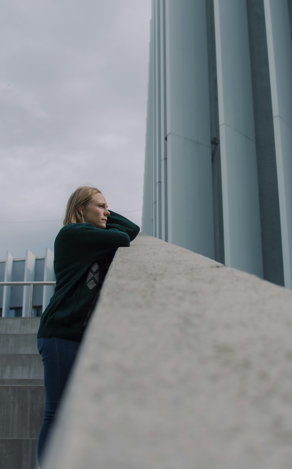 woman in black jacket standing near white concrete building during daytime