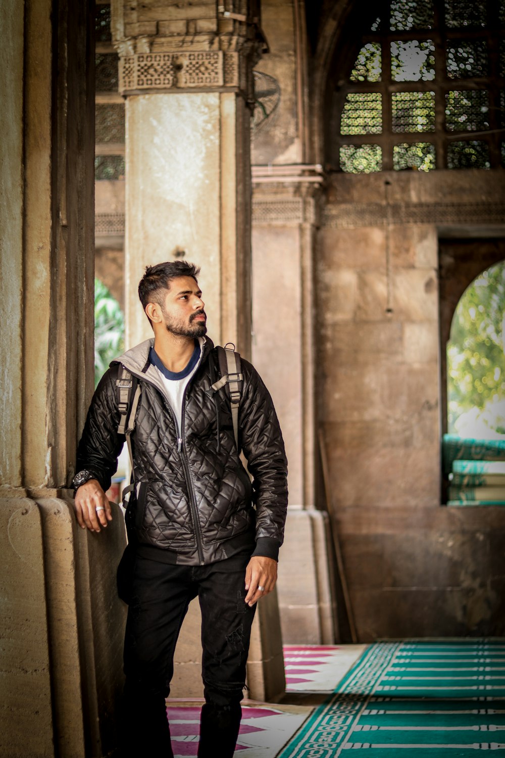 man in black leather jacket standing on hallway