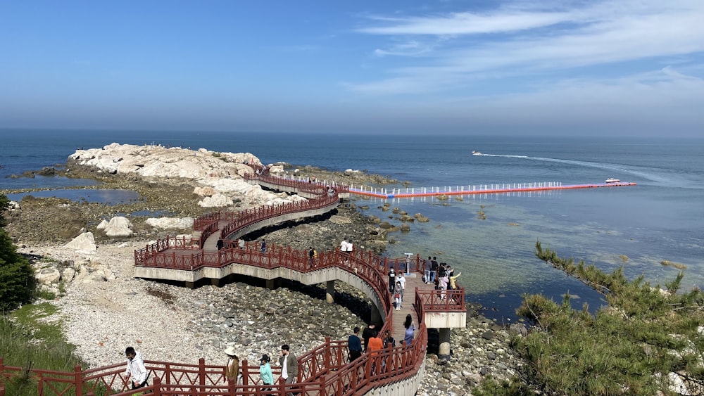 people walking on brown concrete bridge near body of water during daytime