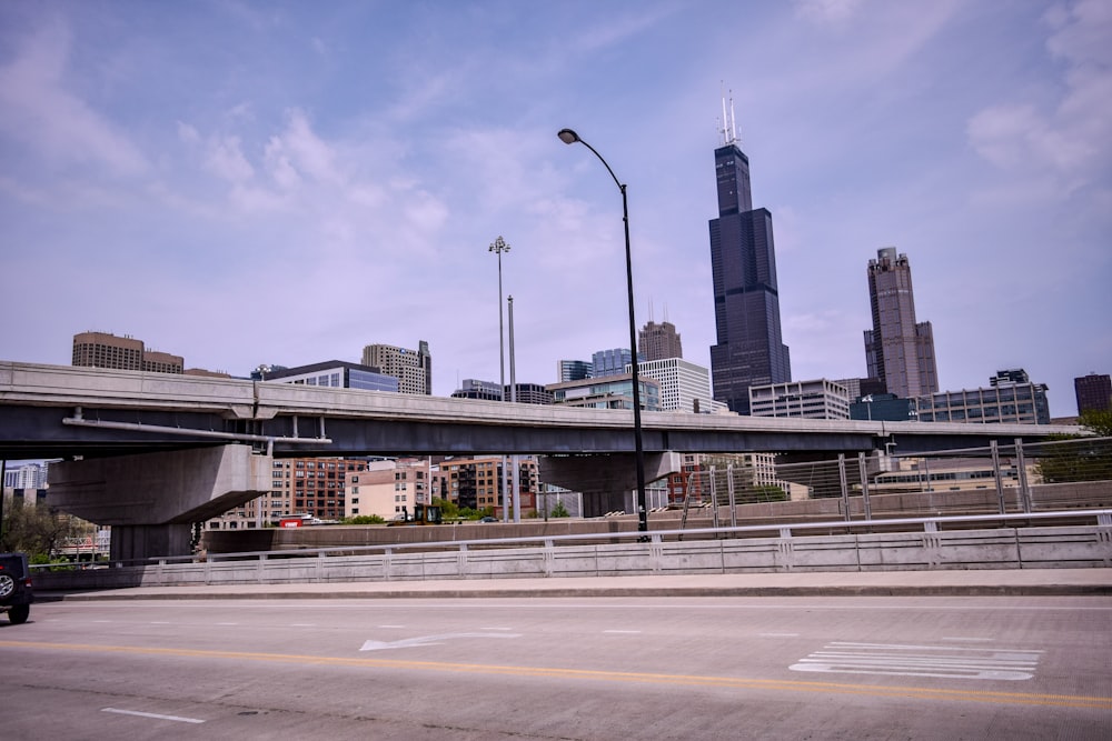 gray concrete bridge near city buildings during daytime