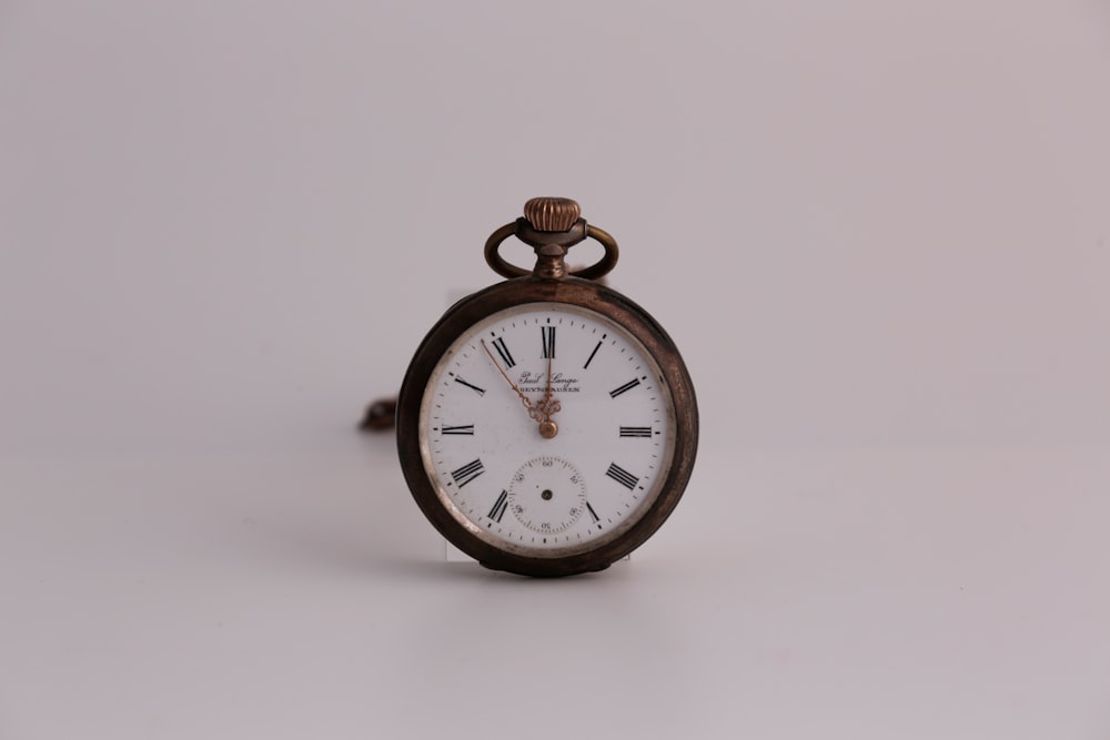 gold and white analog alarm clock