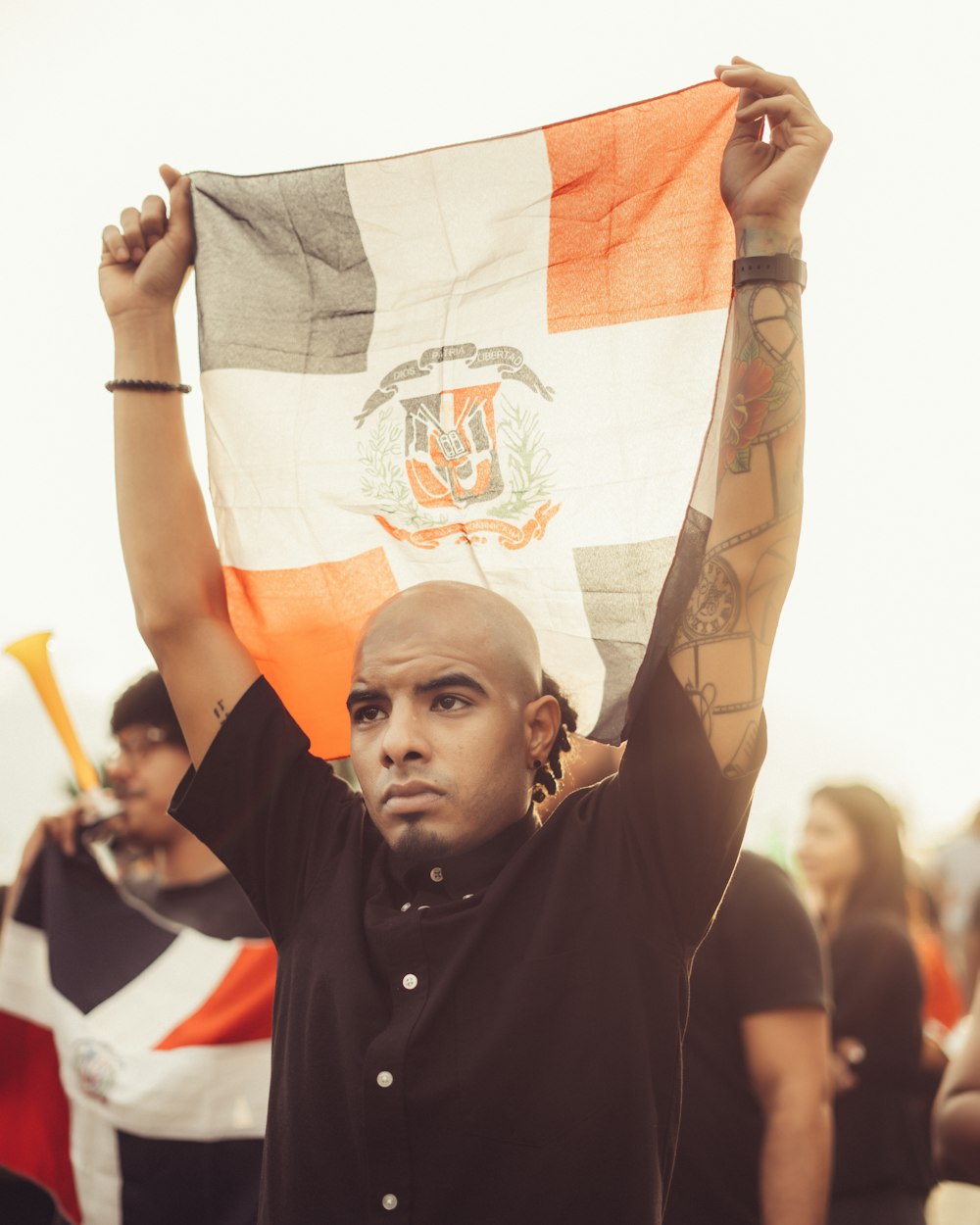 man in black polo shirt holding white and orange textile