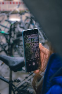 A user uploading photos of a vintage bicycle on a smartphone app.