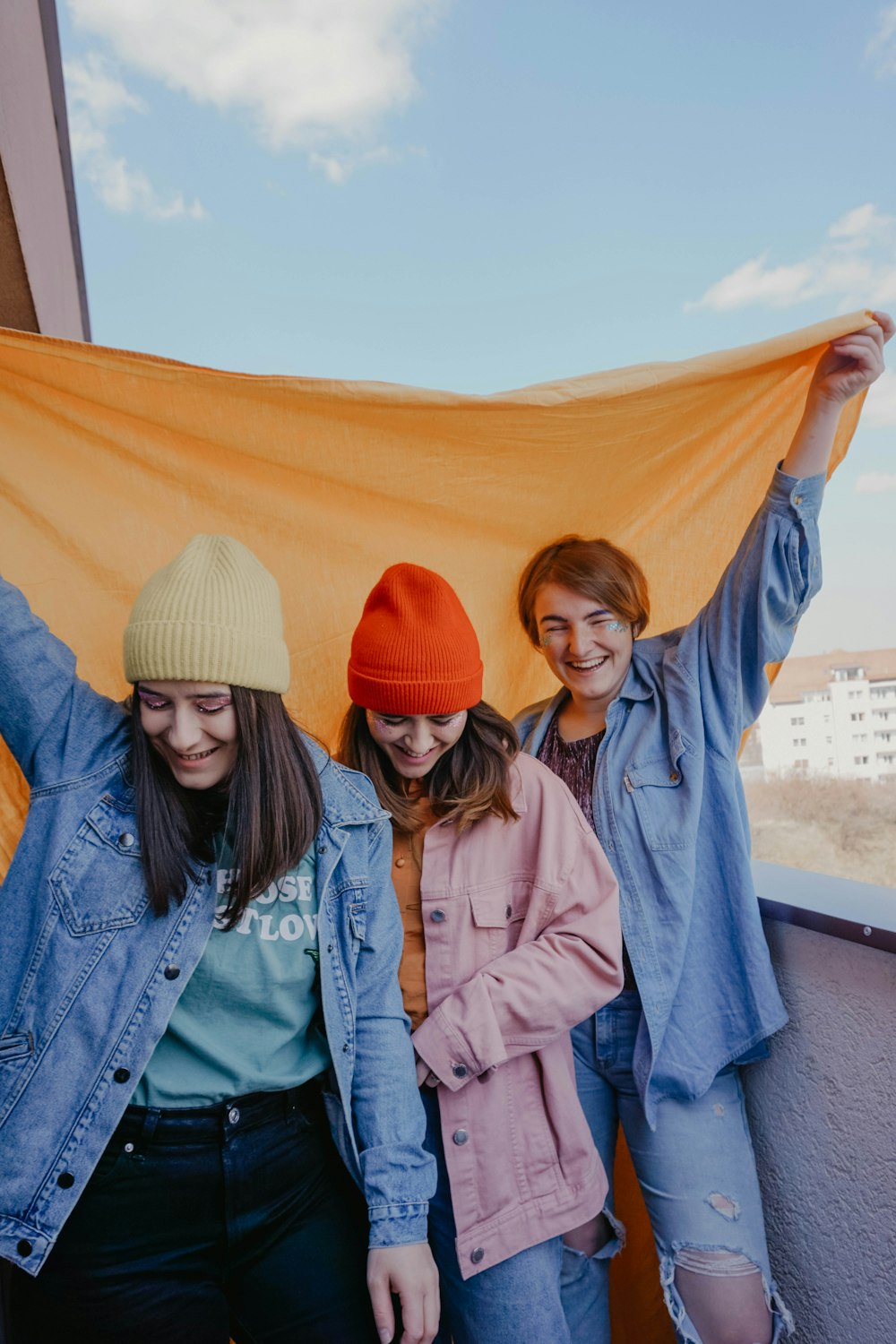 woman in blue denim jacket beside woman in white knit cap