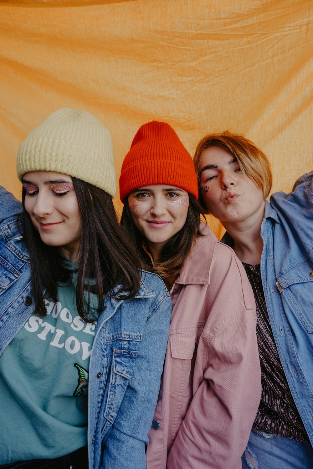 woman in blue denim jacket beside woman in red knit cap