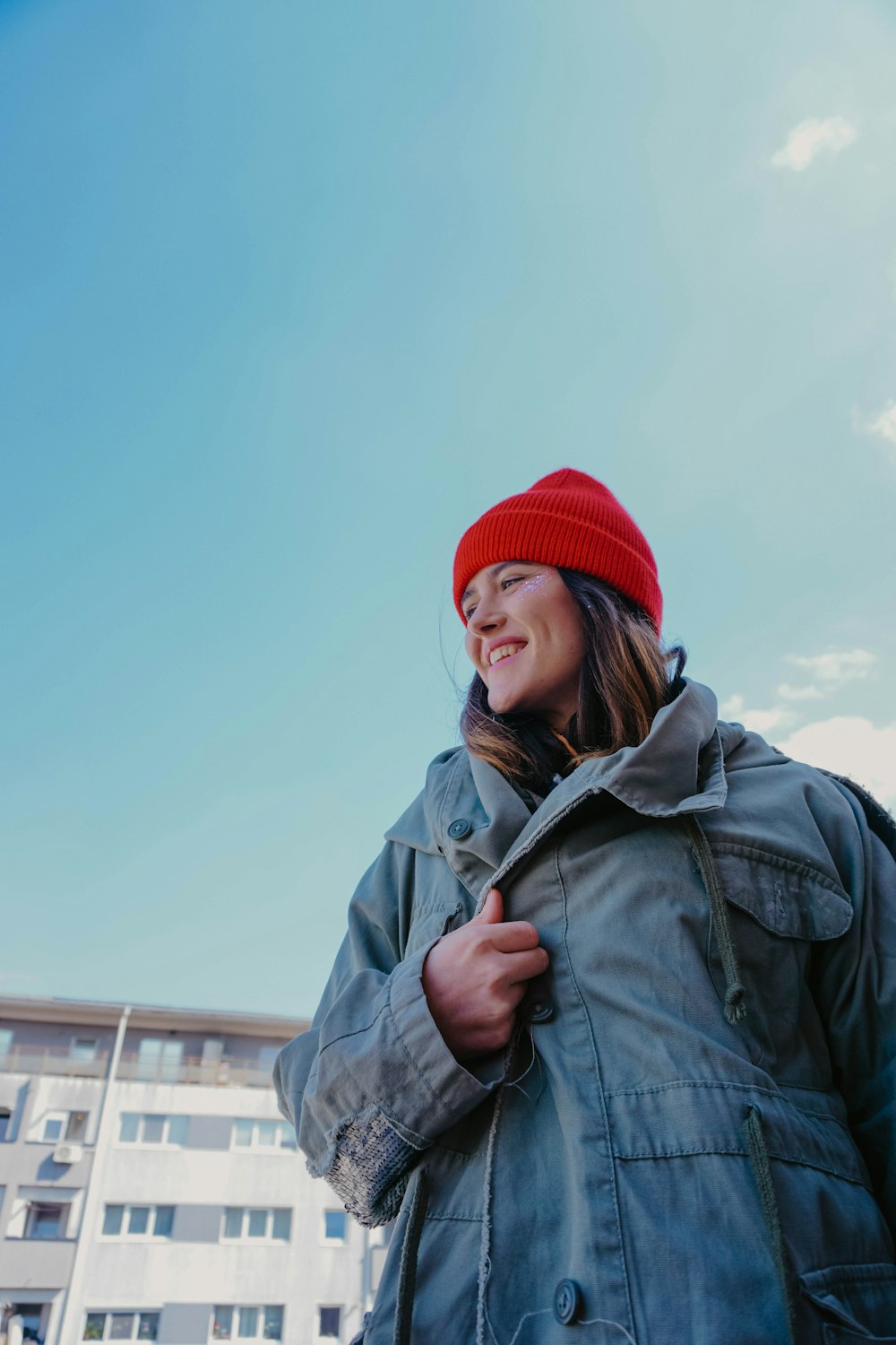 Frau in grauer Jacke und roter Strickmütze