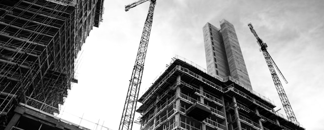 grayscale photo of crane in front of building