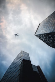 airplane flying over the building during daytime