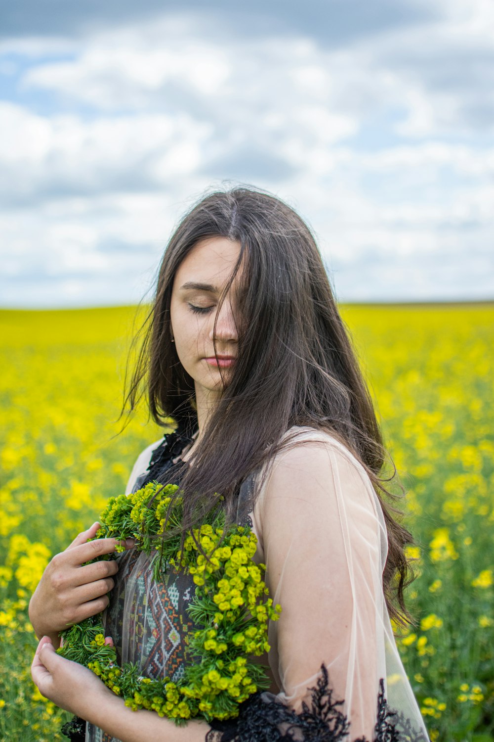 woman in white tank top holding yellow flower bouquet