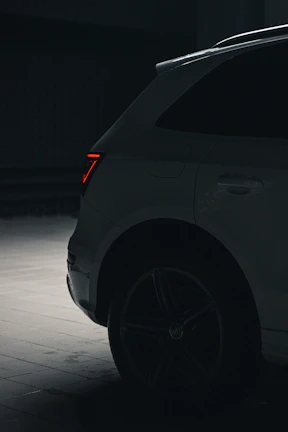 Rear view illuminated by subtle red taillights, emphasizing the sleek silhouette of the Model Y.