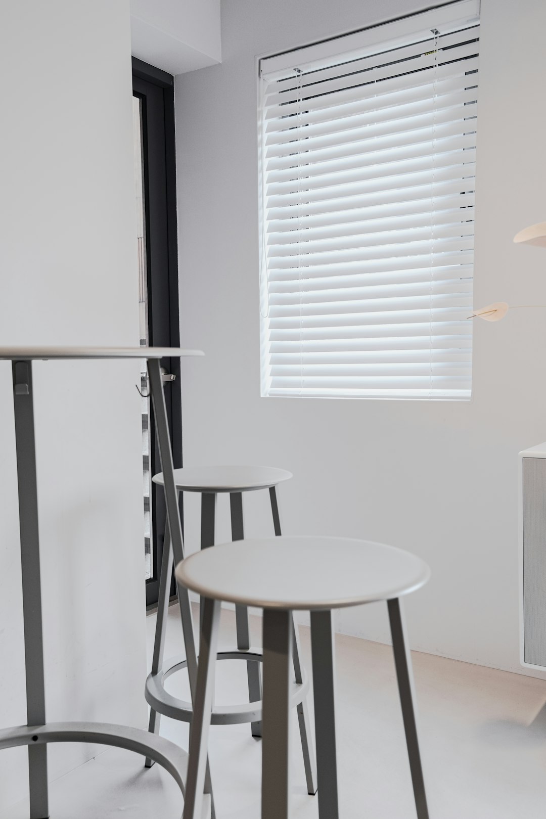 white and black wooden seat beside white window blinds