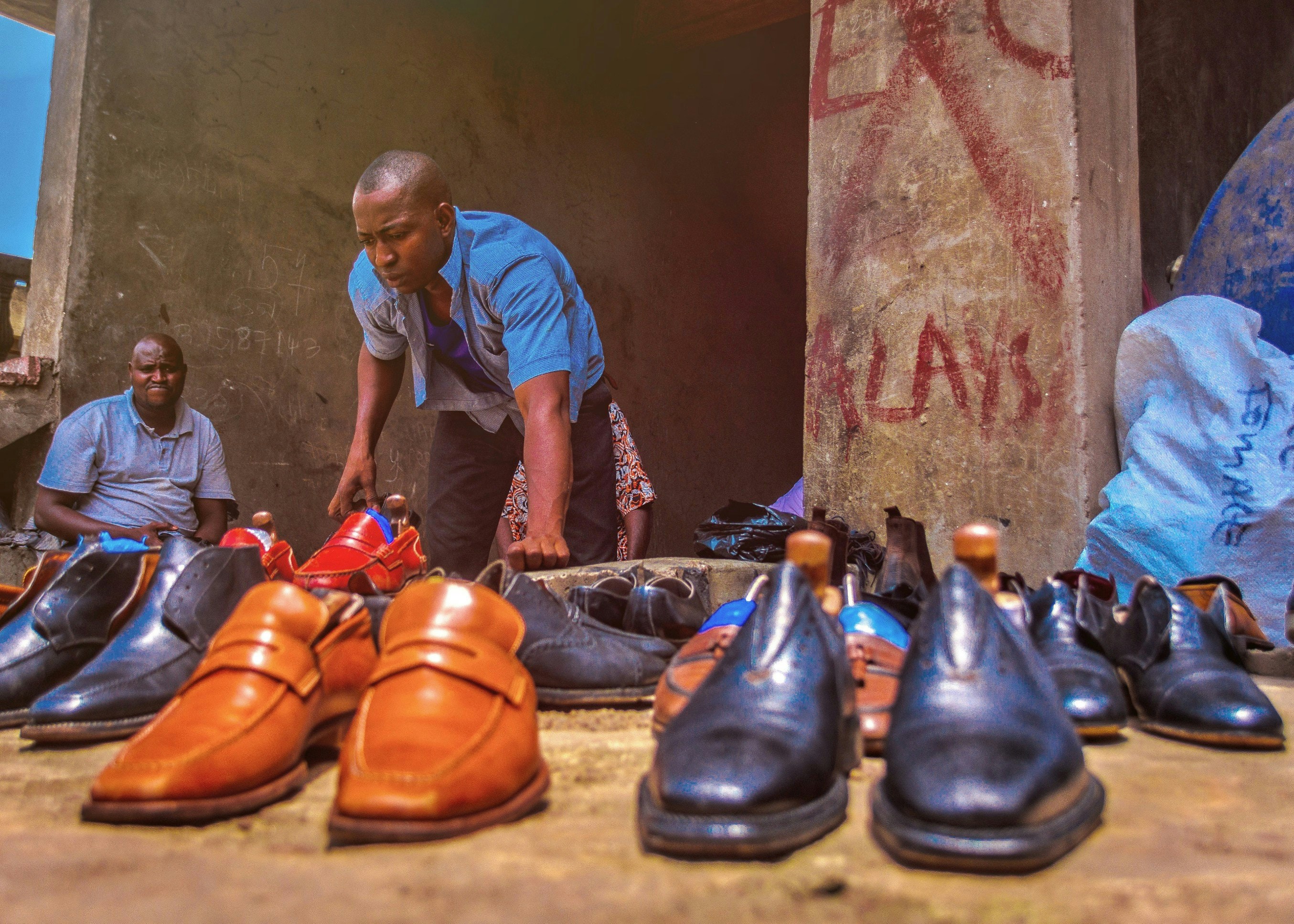 Portrait of a cobbler displaying his shoes