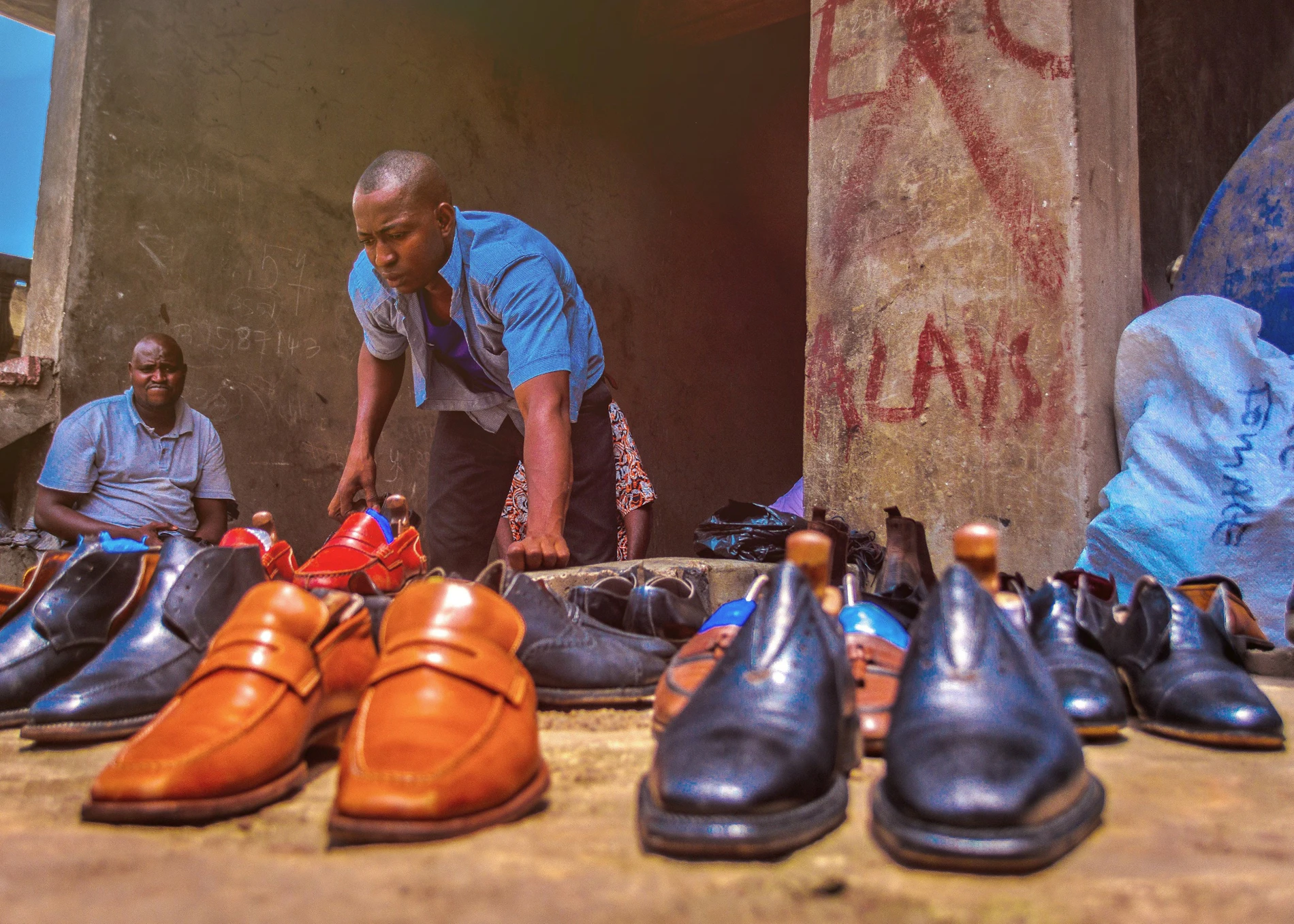 A maker setting out finished leather shoes after polishing