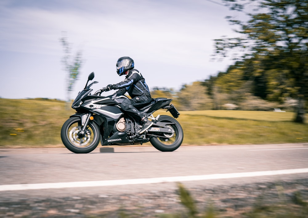 man in black jacket riding black sports bike on road during daytime