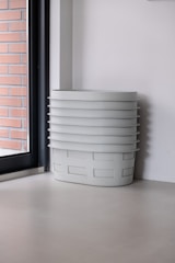 A stack of clean laundry baskets next to a dryer in a home laundry area.