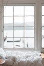 A window seat with cushions overlooking the tranquil waters of Dal Lake.