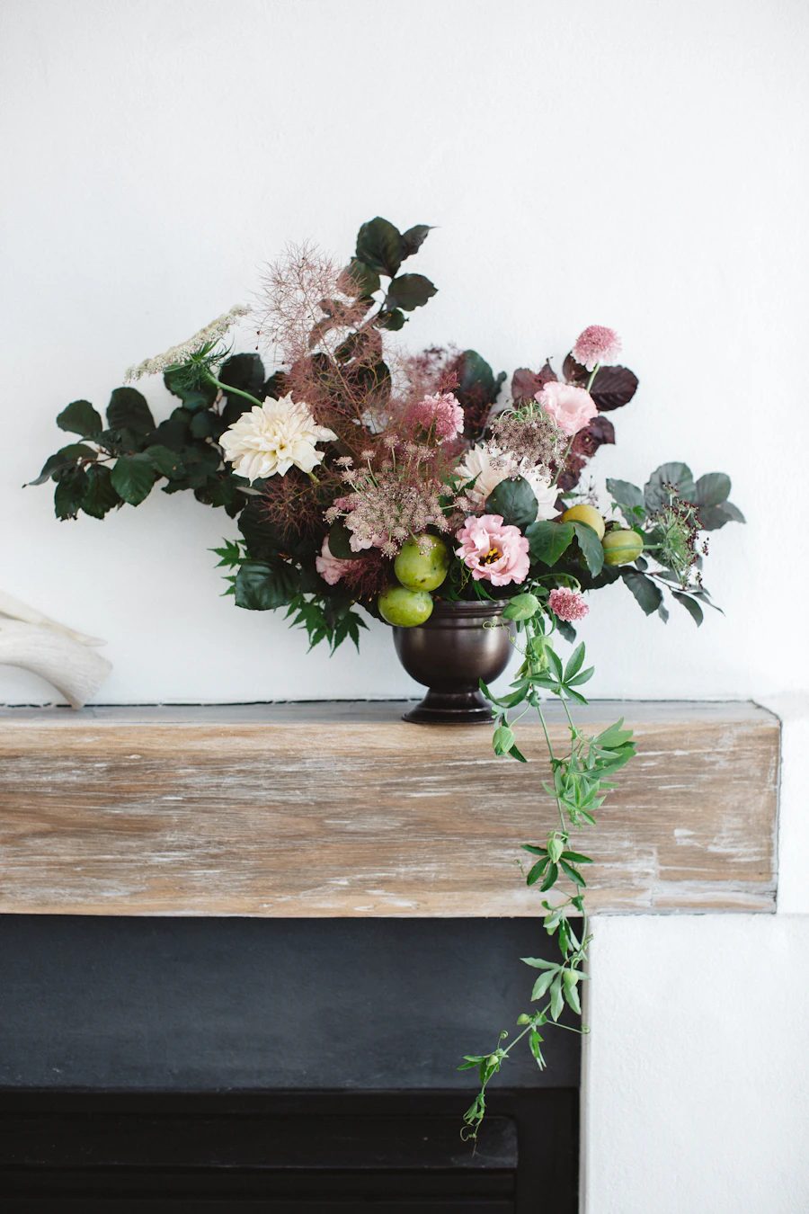 An urn arrangement of soft seasonal flowers