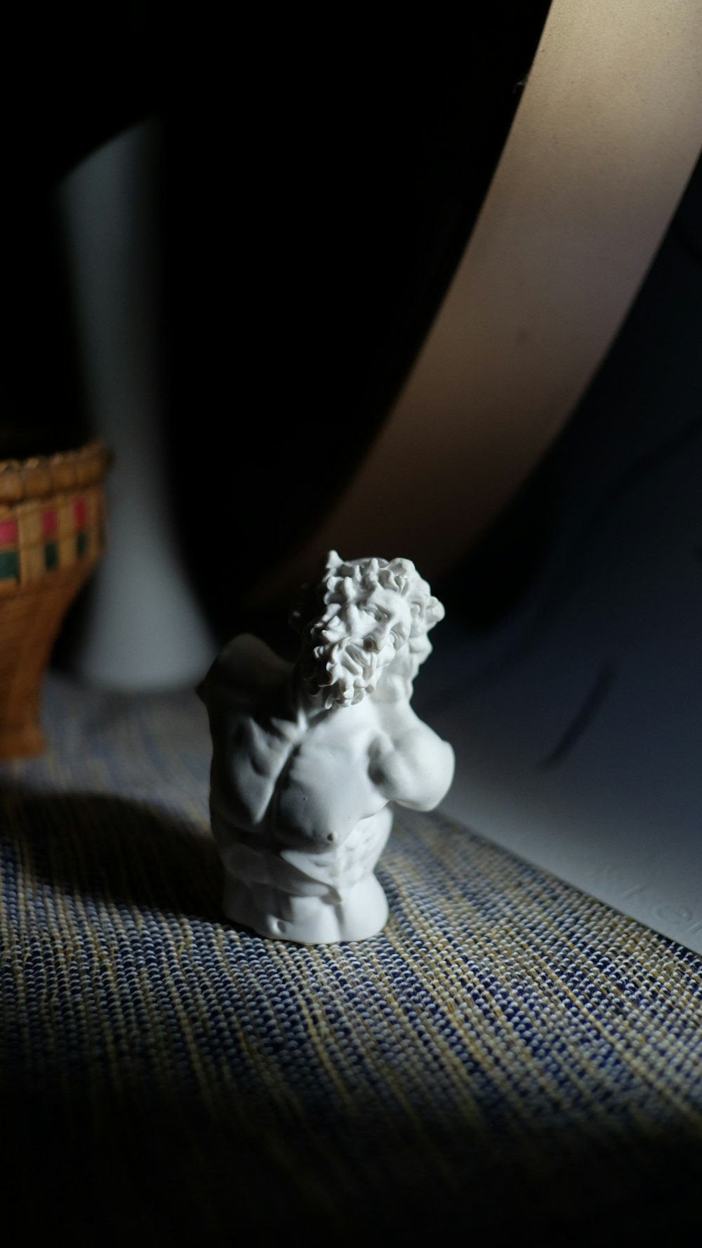 white ceramic figurine on white and blue textile