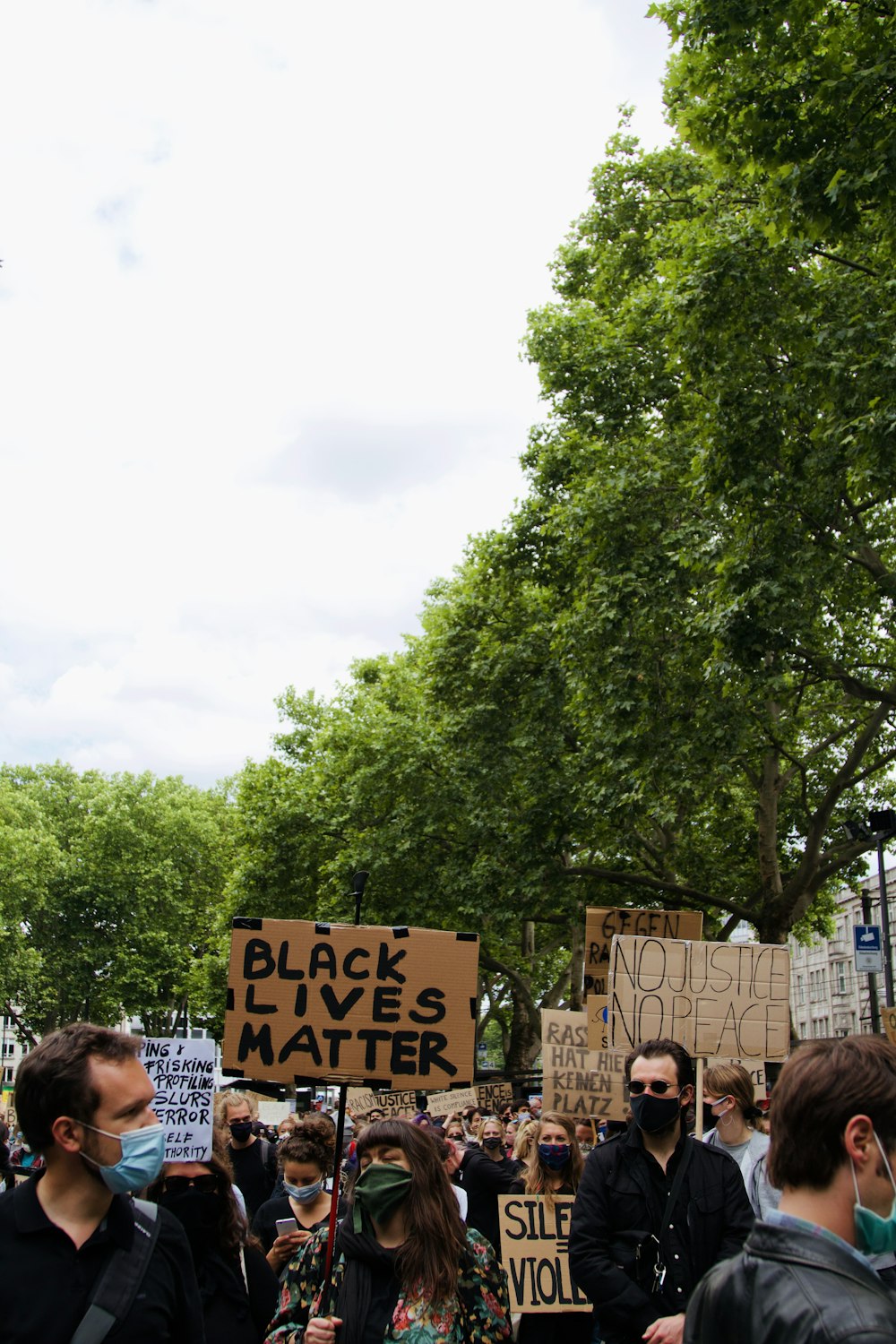 people standing near green trees during daytime