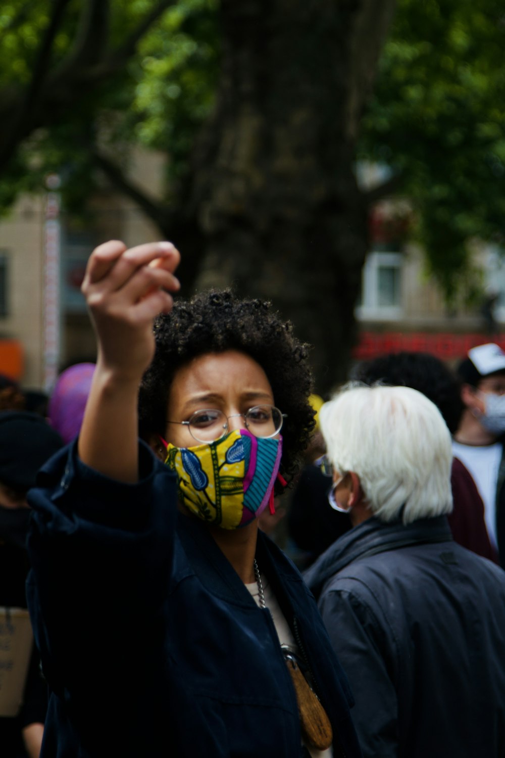 Mann in schwarzer Jacke trägt gelbe Maske