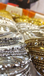 Close-up of handcrafted ethnic accessories with gold detailing on a charcoal surface.