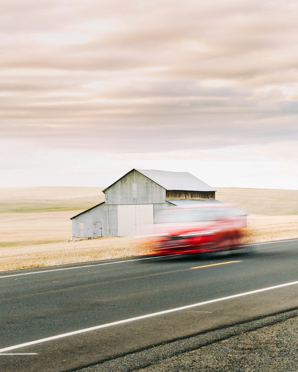 white and red wooden house on gray asphalt road under gray sky