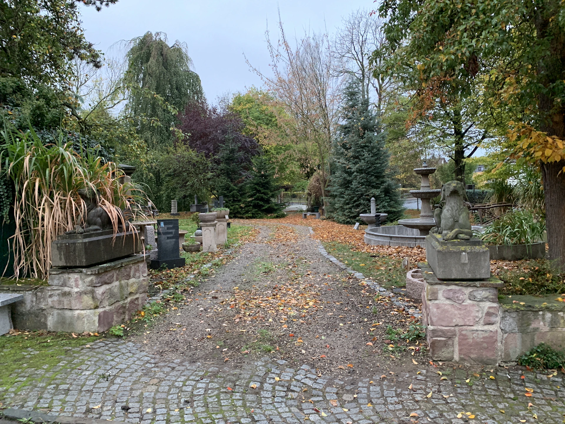 A tranquil garden path lined with blooming flowers and statues, inviting visitors to reflect and relax.