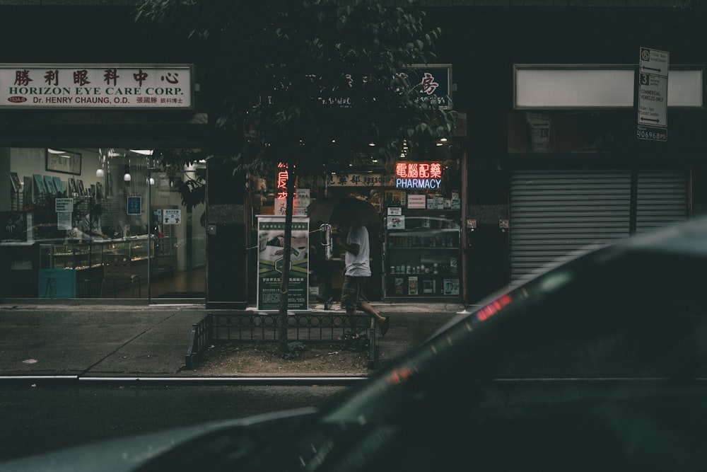 people walking on sidewalk near building during night time