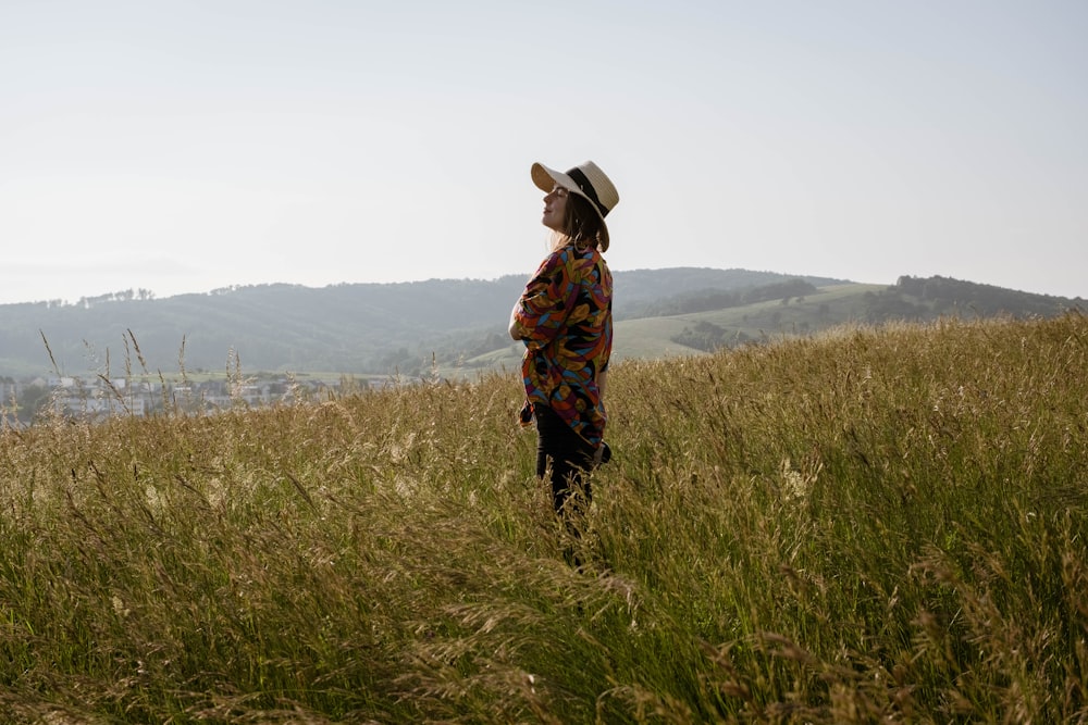 woman in brown and black floral dress standing on green grass field during daytime