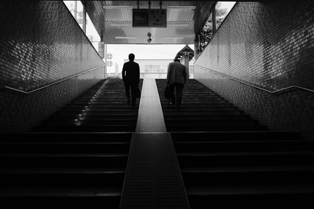 grayscale photo of people walking on the hallway