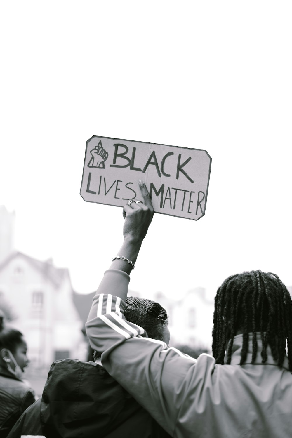 grayscale photo of person holding road sign