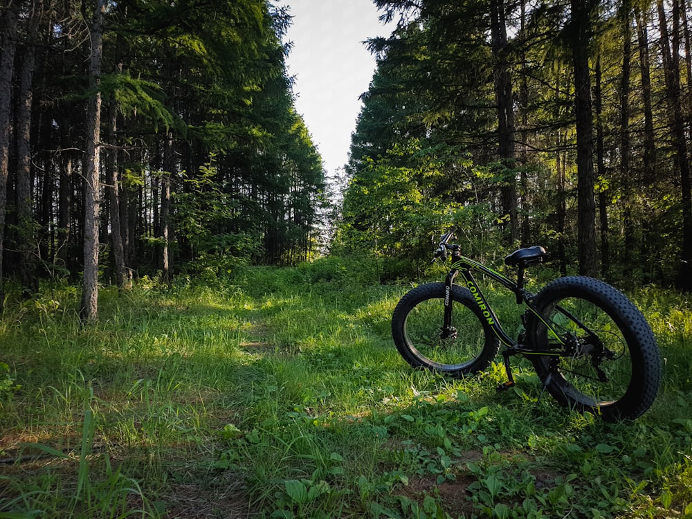 black mountain bike on green grass field during daytime