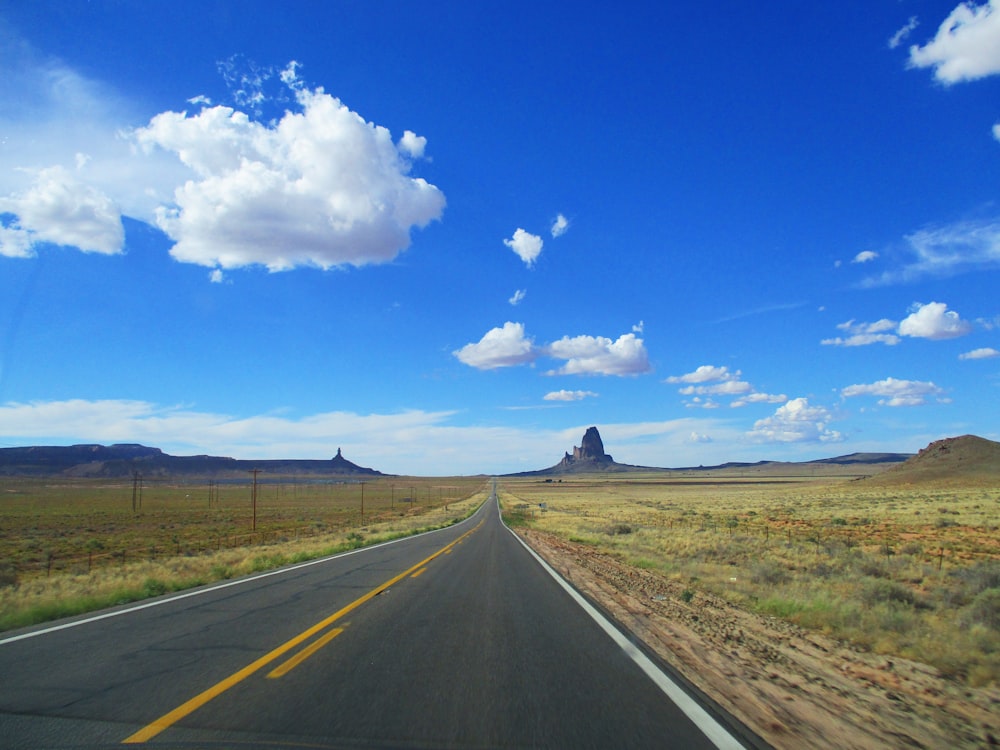 gray asphalt road under blue sky during daytime