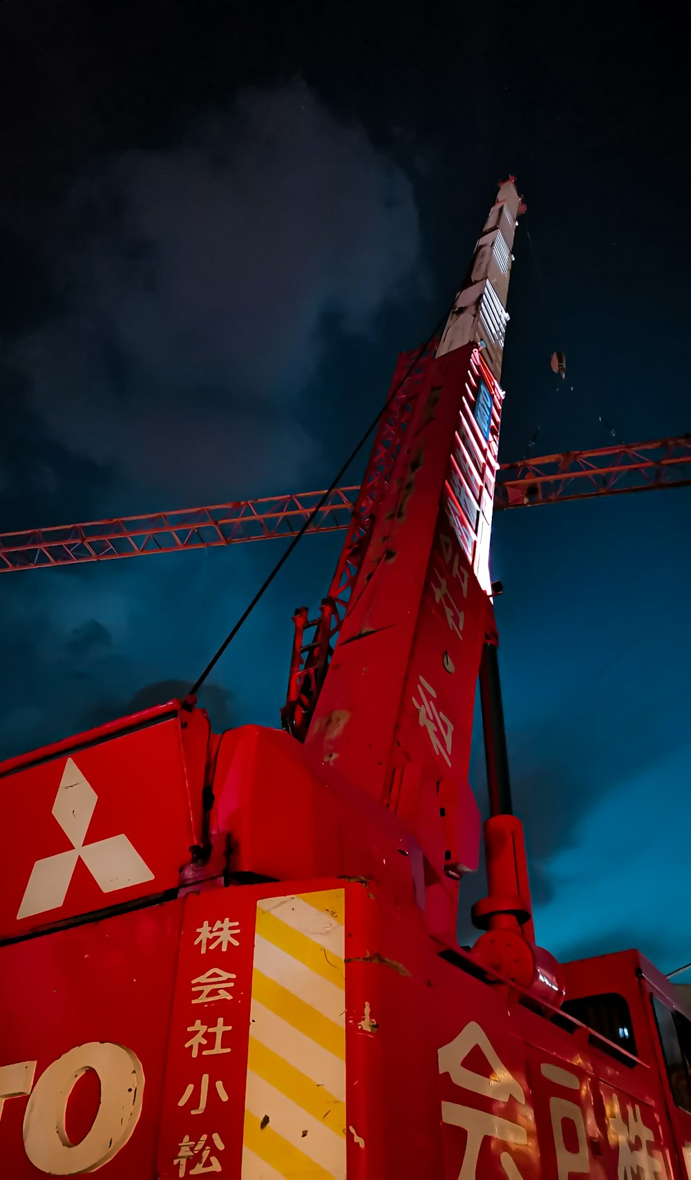 red and white crane under cloudy sky during daytime