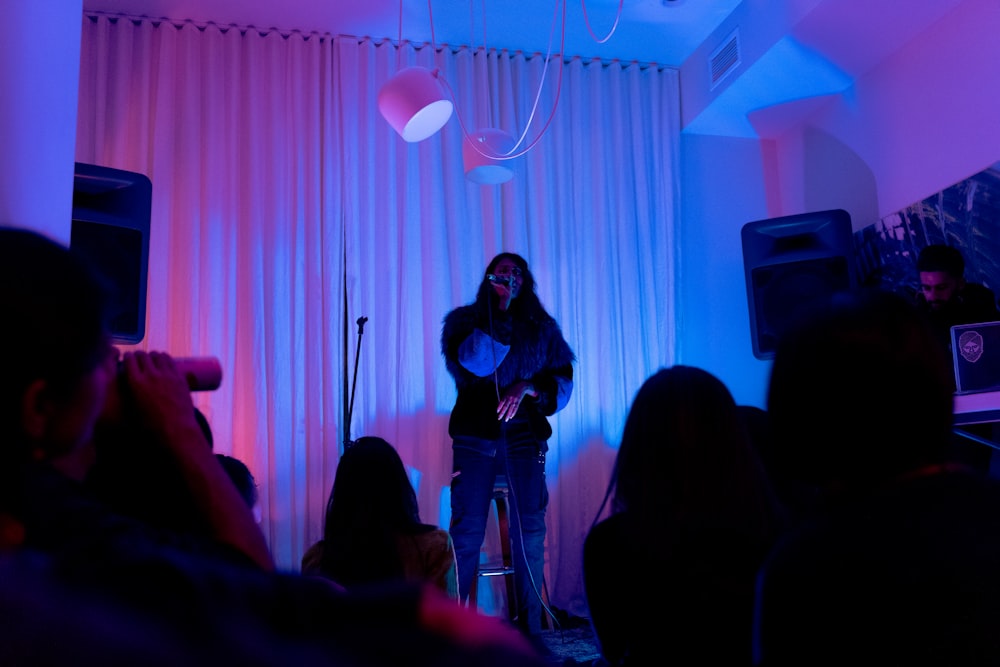 man in black shirt singing on stage