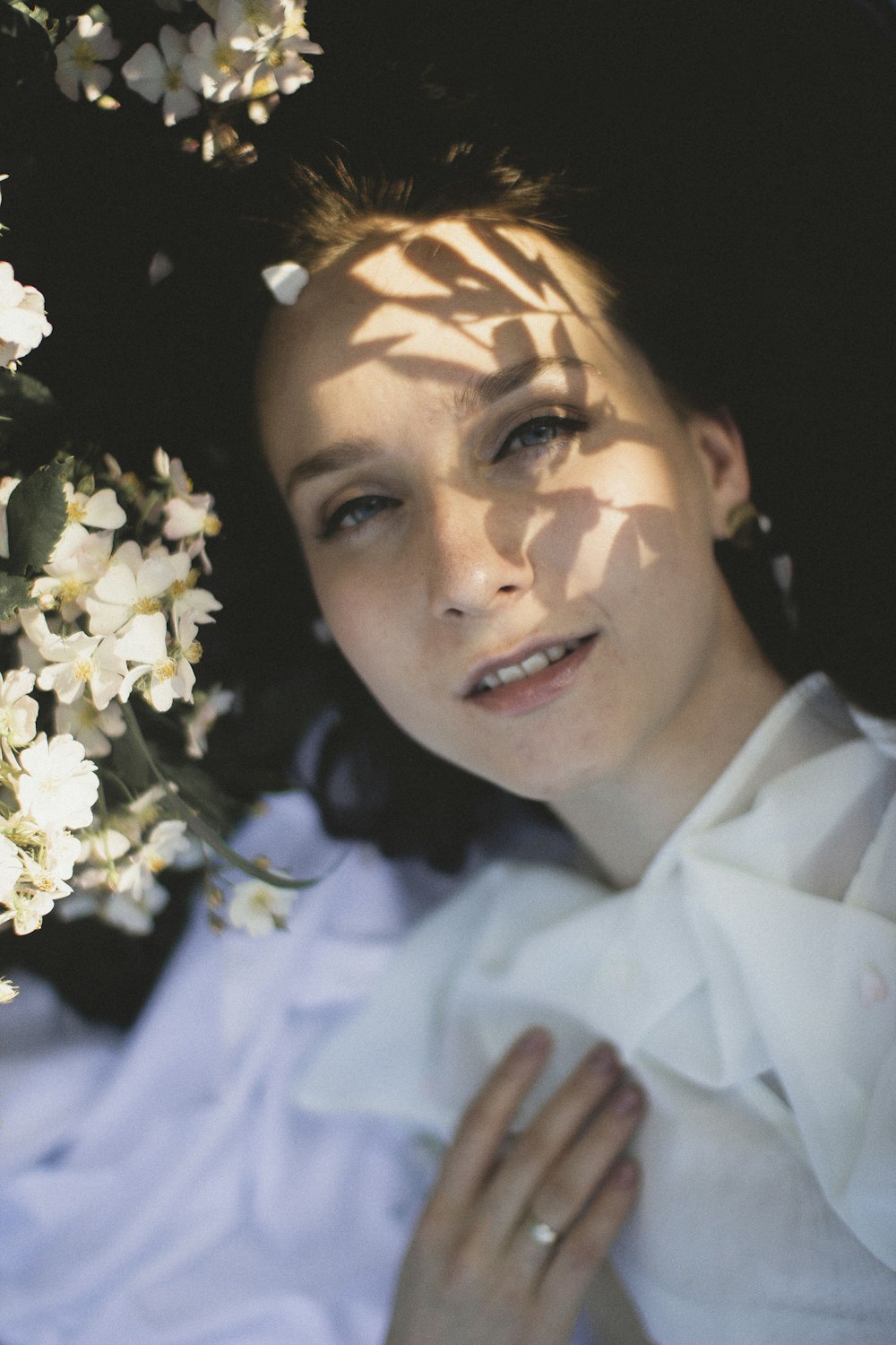 woman in white collared shirt with white flower on her face