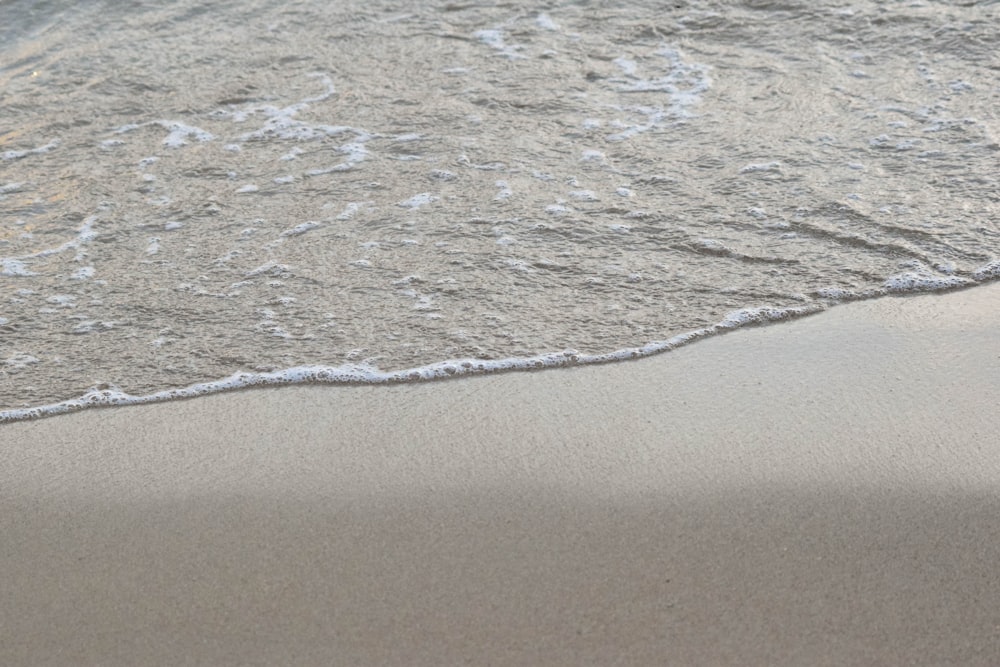 sea waves on brown sand during daytime