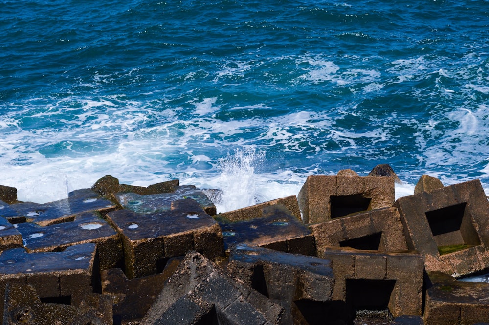 brown concrete blocks near body of water during daytime