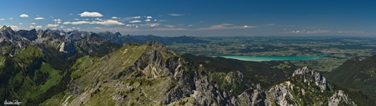 green and brown mountain beside blue sea under blue sky during daytime in Linderhof Germany