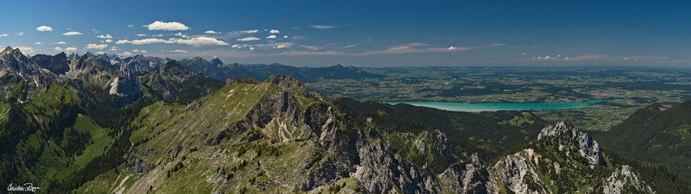 green and brown mountain beside blue sea under blue sky during daytime