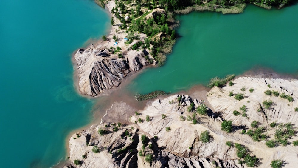 aerial view of green lake and gray rocky mountain during daytime